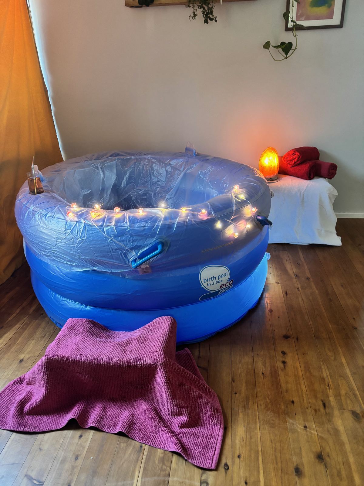 Mini Birth Pool in a Box ready to set up, with warm towels and a salt lamp
